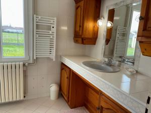 ein Bad mit einem Waschbecken, einem Spiegel und einem Fenster in der Unterkunft Les clés de Jonzacconciergerie, Villa les oiseaux in Jonzac