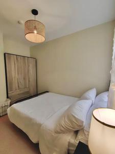 - une chambre avec un grand lit blanc et deux lampes dans l'établissement Ezzel’s Place at Marina Spatial Dumaguete City, à Dumaguete