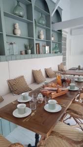Maison Charmeilles - Gîte touristique - Coliving في Fronsac: طاولة خشبية عليها طعام