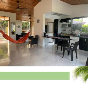 Una cocina y una sala de estar con mesa y sillas. en Casa con piscina privada Vía melgar Carmen de Apicalá, en Melgar