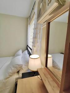 um pequeno quarto com um espelho e uma cama em Ezzel’s Place at Marina Spatial Dumaguete City em Dumaguete