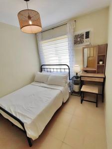 um quarto com uma cama, uma mesa e um espelho em Ezzel’s Place at Marina Spatial Dumaguete City em Dumaguete