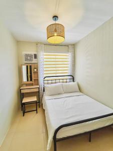 Habitación pequeña con 2 camas y ventana en Ezzel’s Place at Marina Spatial Dumaguete City en Dumaguete