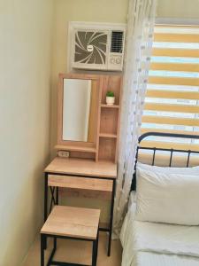 1 dormitorio con mesa, espejo y cama en Ezzel’s Place at Marina Spatial Dumaguete City en Dumaguete