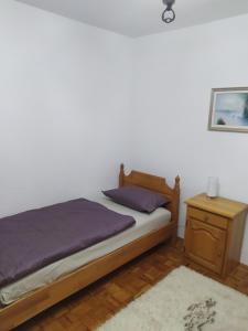 a bedroom with a bed with a nightstand and a bed sidx sidx sidx sidx at Apartman Zdenka in Livno
