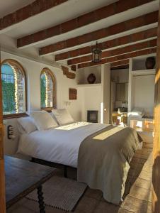 ein Schlafzimmer mit einem großen Bett und zwei Fenstern in der Unterkunft Casa Hostalets - Renovated casa in the middle of the olive trees near the beach in Riudoms