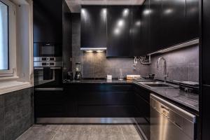a kitchen with black cabinets and a sink at Akicity Amoreiras Bold in Lisbon