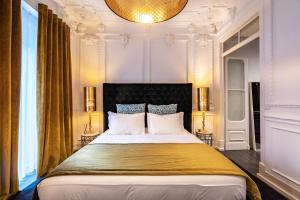 - une chambre avec un grand lit et une couverture jaune dans l'établissement Akicity Amoreiras Bold, à Lisbonne