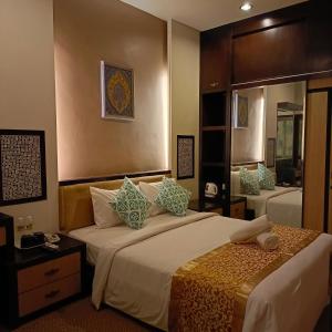 1 dormitorio con 1 cama grande y espejo en Hotel Zara, en Sungai Petani