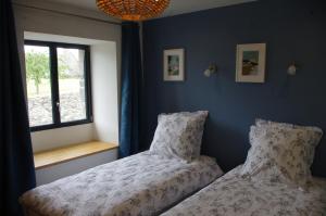 a bedroom with two beds next to a window at Superbe Maison en baie du Mont St Michel in Vains