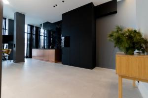 a living room with black cabinets and a potted plant at Rentroom2 in Polanica-Zdrój