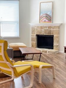 uma sala de estar com uma cadeira amarela e uma lareira em Family Perfect with Fireplace Vacation Home em Little Elm