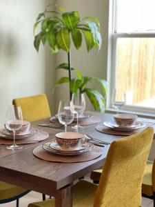 uma mesa de madeira com pratos e copos de vinho em Family Perfect with Fireplace Vacation Home em Little Elm