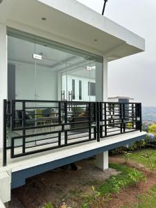 uma casa de vidro numa colina com uma varanda em Prayer Mountain Cove em Kampala