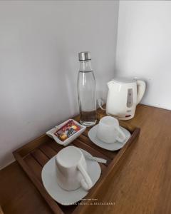 金塔馬尼的住宿－caldera hotel，盘子,杯子,桌子上的瓶子