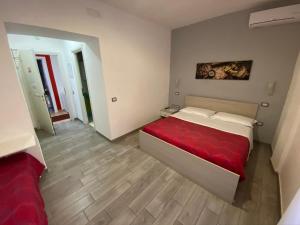 a bedroom with a bed with a red blanket at Coral Rooms in Torre del Greco