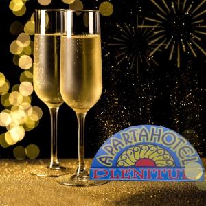 2 Gläser Champagner auf einem Tisch mit Feuerwerk in der Unterkunft Aparta Hotel Plenitud in Palmira