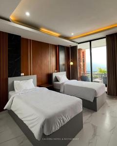 Cette chambre dispose de deux lits et d'un balcon. dans l'établissement caldera hotel, à Kintamani