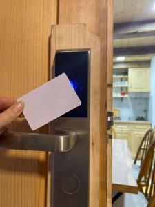 a person is holding a piece of paper in a door at Brvnara Etno Lux in Mokra Gora