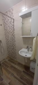 bagno bianco con lavandino e doccia di Apartmani Kovačević Banja Vrujci a Gunjica