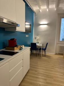 een keuken met witte kasten en een tafel met stoelen bij Casa di Susi in Milaan