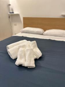 twee witte handdoeken bovenop een bed bij Casa di Susi in Milaan