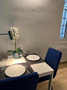 een eettafel met borden en blauwe stoelen bij Casa di Susi in Milaan