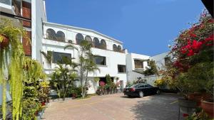 リマにあるCasa Bella Boutique Hotel San Isidroの建物の前の駐車場に駐車された車