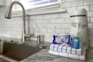 a counter top with a pile of paper towels and a sink at Flip Flops & Sun in Gulf Shores +37 photos