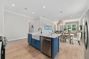 a kitchen with blue cabinets and a dining room at Feelin' Good Again in Orange Beach