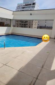 a yellow smiley face ball next to a swimming pool at Flat Manhattan Residence Service in São Paulo