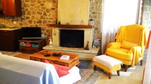 1 dormitorio con silla amarilla y chimenea en Αντίρρινο - Guest house, en Arachova