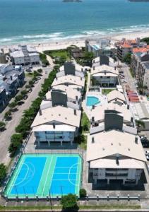 una vista aérea de una playa con casas y una pista de tenis en Apartamento Ingleses Norte 30m da praia, en Florianópolis