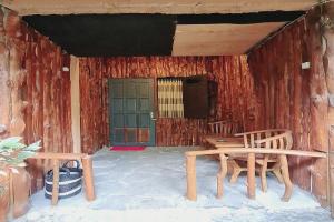 un porche con 2 sillas de madera y una puerta verde en Larasati Homestay en Kalirejo