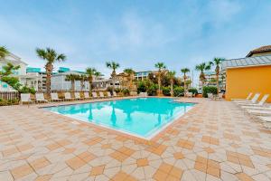 a swimming pool with chairs and palm trees at Miramar Beach Villas Building 6 Unit B in Destin