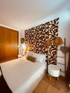 a bedroom with a white bed and a black and white wall at Sunset Beach House in Zambujeira do Mar