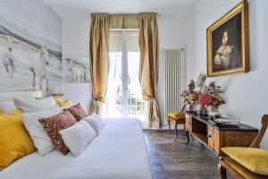een slaapkamer met een wit bed en een raam bij Luxe Garden Apt for 2nr Bologna in Casalecchio di Reno