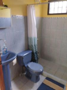 een badkamer met een blauw toilet en een wastafel bij House in Cuajiniquil ,Belen de nosarita in Cuajiniquil