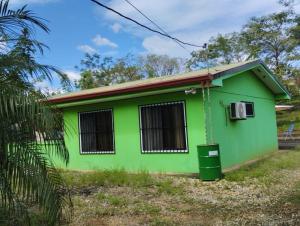 een groen huis met een vuilnisbak ervoor bij House in Cuajiniquil ,Belen de nosarita in Cuajiniquil