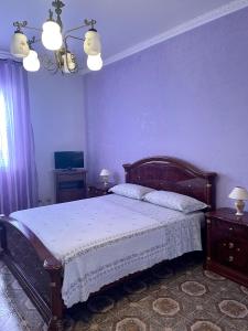 a bedroom with a bed and a purple wall at ANNABELL'S in Cassibile