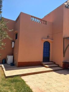 Una casa con una puerta azul a un lado. en Villa Générosité en Marrakech