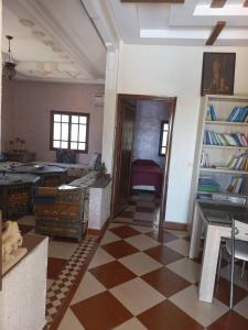 uma sala de estar com um piso xadrez e um quarto com uma porta em Villa Générosité em Marraquexe