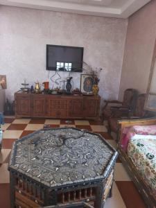 sala de estar con TV y mesa en Villa Générosité en Marrakech