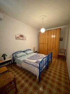 a bedroom with a blue bed and a wooden cabinet at ANNABELL'S in Cassibile