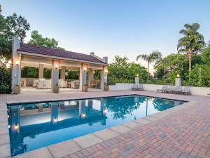 a swimming pool in front of a house at Monkey Thorn Lodge & Wellness Spa - Adults Only in White River