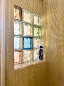 La salle de bains est pourvue d'une fenêtre en verre sur un mur carrelé. dans l'établissement ANNABELL'S, à Cassibile