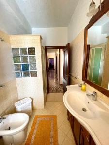 La salle de bains est pourvue d'un lavabo, de toilettes et d'un miroir. dans l'établissement ANNABELL'S, à Cassibile