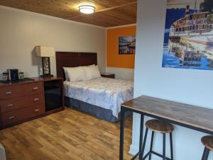 a bedroom with a bed and a table and a desk at Riverboat Inn & Suites in Madison