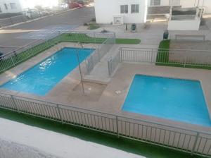 una vista aérea de dos piscinas en un edificio en Departamento a pasos de la playa y centros comerciales, en La Serena