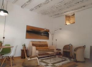 a living room with a couch and a table and chairs at La gota de leche 1 in Sanlúcar de Barrameda